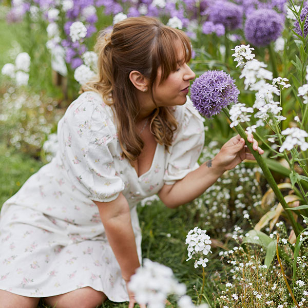 Stacey smelling flowers in field